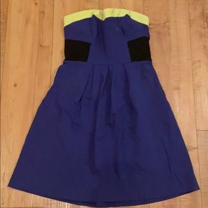 Strapless mini dress with yellow band around top.